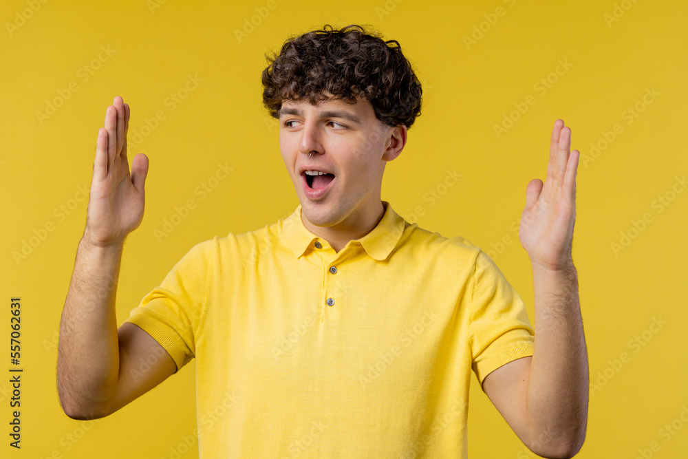 Big large concept. Man showing invisible abstract subject or object sizes. Size matters. Yellow studio background Big large concept. Man showing invisible abstract subject or object sizes. Size matters. Yellow studio background