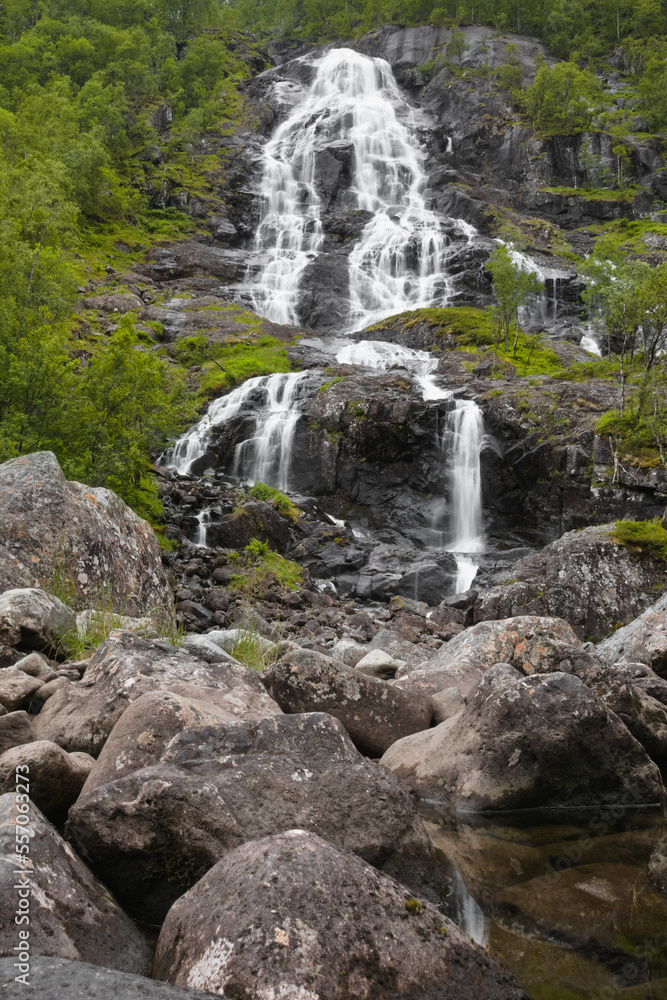 A beautiful waterfall in the forest with several smaller streams flowing over the rocks. A beautiful waterfall in the forest with several smaller streams flowing over the rocks.