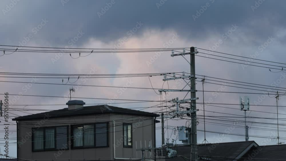Clouds move over suburban house behind web of electrical wires at dawn Clouds move over suburban house behind web of electrical wires at dawn
