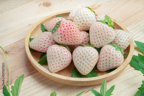 Fresh Pink Snow Strawberry in wooden plate on wooden background, White and Pink snow Strawberries on wooden Background.