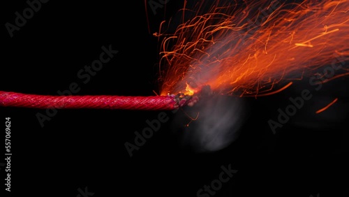 A macro shot of a burning fuse in front of a black background. photo