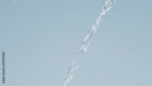 Beautiful pure Water jet flow in slow motion on blue background. Full HD slow motion video of water flowing from top to bottom.