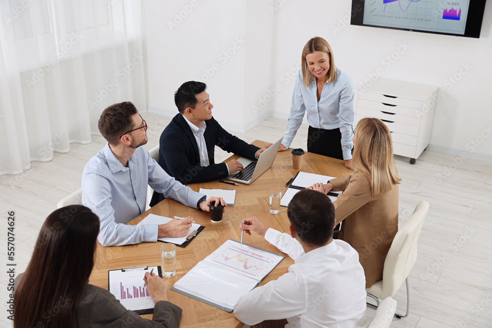 Businesswoman having meeting with her employees in office