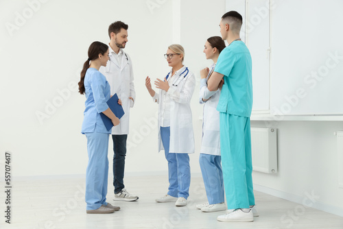 Medical doctors in uniforms having discussion in clinic photo