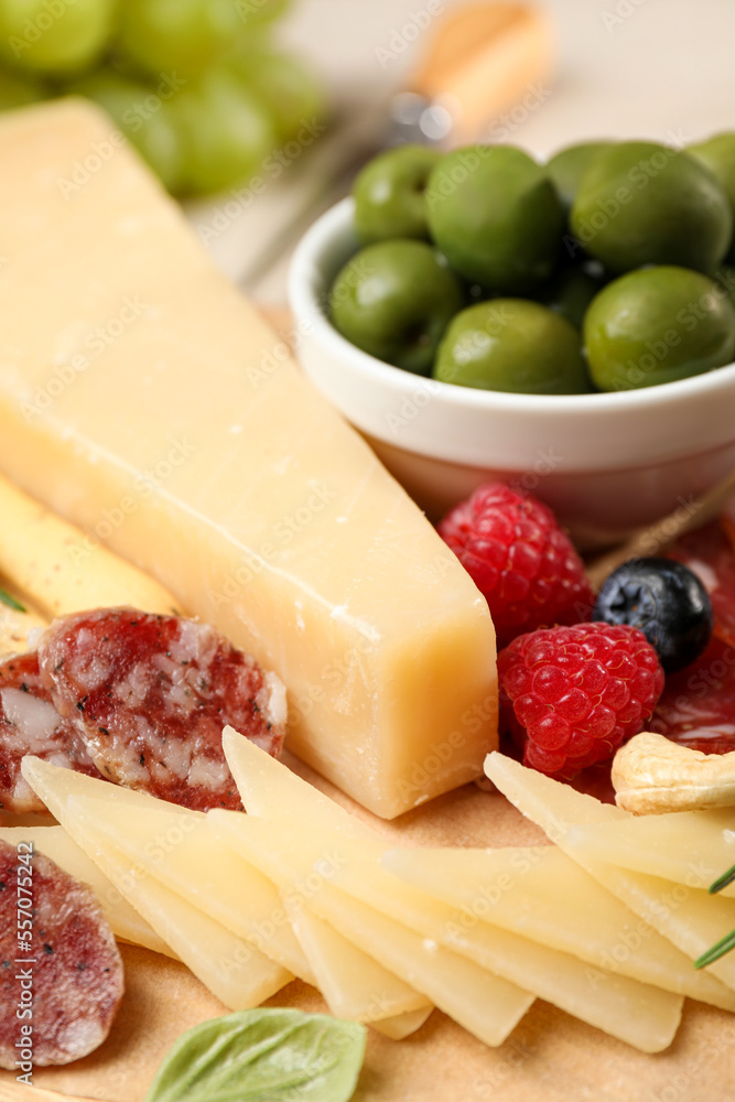 Snack set with delicious Parmesan cheese on wooden board, closeup
