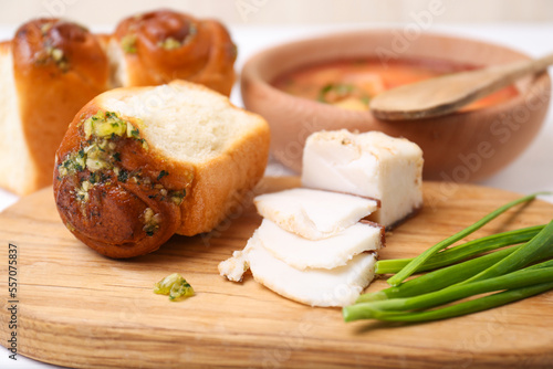 Delicious pampushky (buns with garlic), green onions and salo served for borsch on table, closeup. Traditional Ukrainian cuisine photo