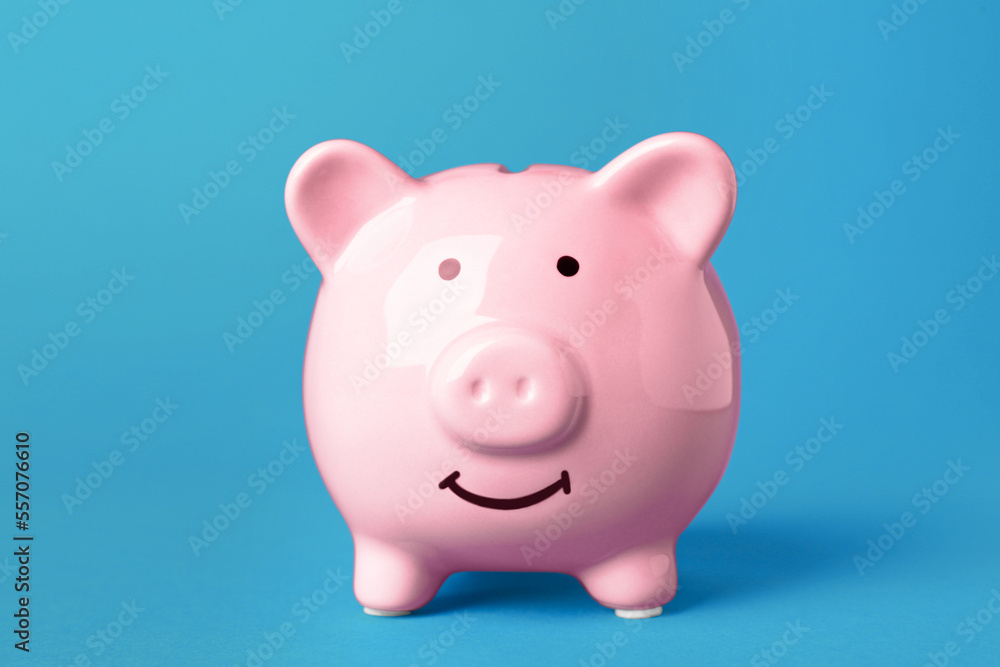Ceramic piggy bank on turquoise background. Financial savings