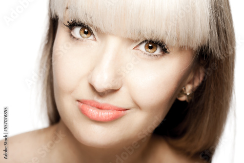 Close up portrait of a beautiful brunette girl with blond bangs fringe. Positive face expression..