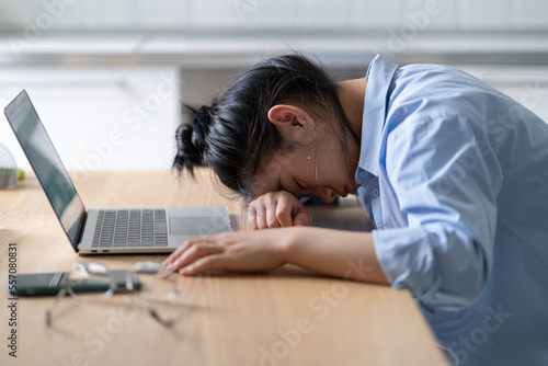 Work burnout. Tired exhausted asian woman feeling energy depletion or exhaustion, overworked stressed girl putting head down on table, suffering from chronic job stress. Overwork concept