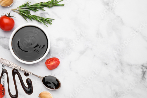 Organic balsamic vinegar and cooking ingredients on white marble table, flat lay. Space for text