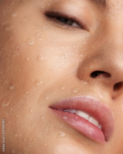 Girl's face with water drops on her face Looks at the camera Blue eyes Close up Horizontal frame Smooth skin Make up Beauty ,Cosmeics,Fashion Close up