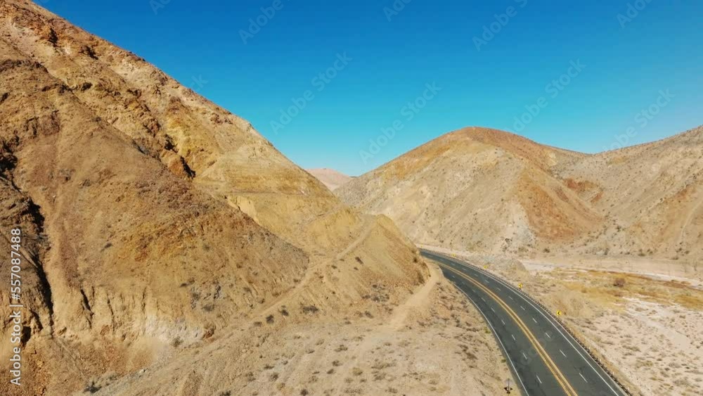 Vehicles driving along California state highway 58 through the arid landscape of the Mojave Desert - ascending aerial view Vehicles driving along California state highway 58 through the arid landscape of the Mojave Desert - ascending aerial view