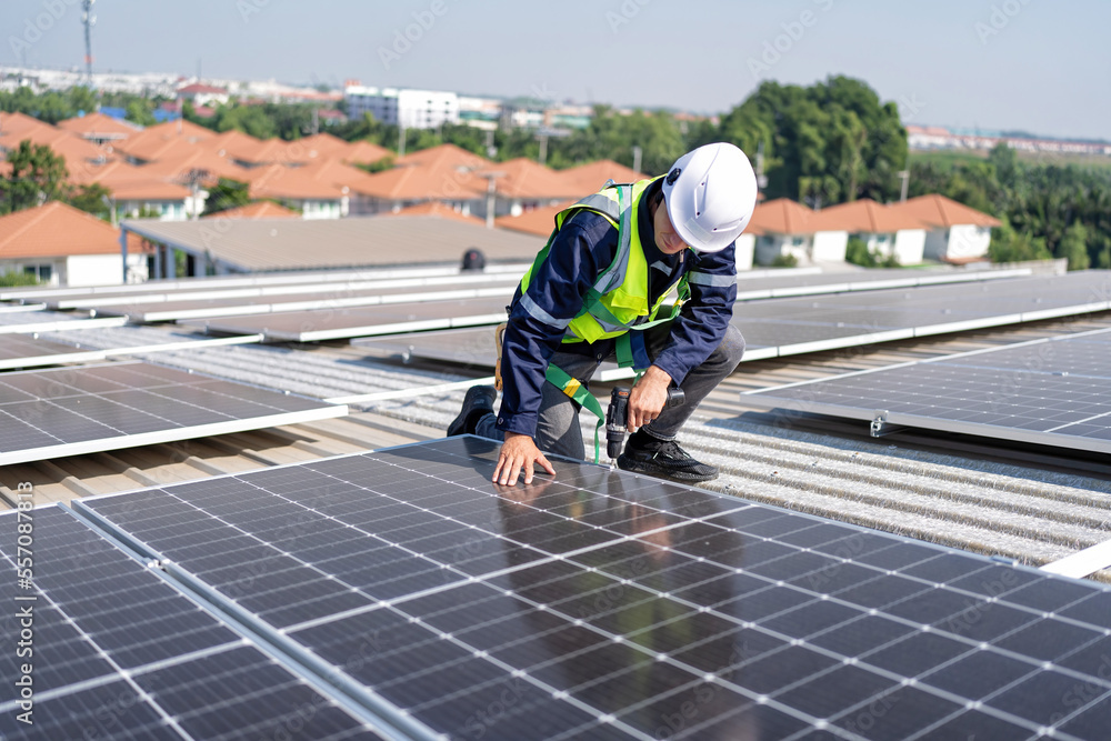 Engineer on rooftop kneeling next to solar panels photo voltaic with tool in hand for installation Engineer on rooftop kneeling next to solar panels photo voltaic with tool in hand for installation