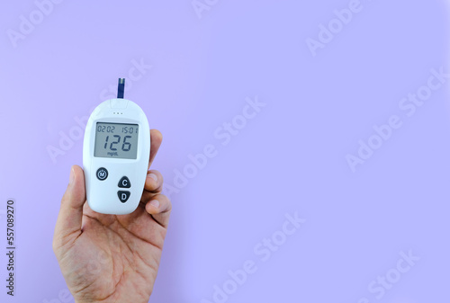 Female hand. Checking for diabetes and checking for hyperglycemia with a digital blood glucose meter. Blood test results 126 are diabetes according to international standards. Health care and medical  photo