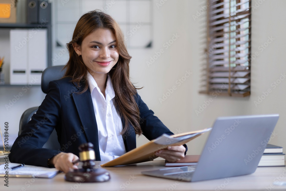 Attractive young lawyer in office Business woman and lawyers discussing contract papers with brass scale on wooden desk in office. Law, legal services, advice, Justice and real estate concept. Attractive young lawyer in office Business woman and lawyers discussing contract papers with brass scale on wooden desk in office. Law, legal services, advice, Justice and real estate concept.