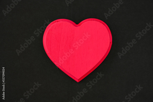 Red wooden heart on a back background, celebrate romance on Valentine’s Day 