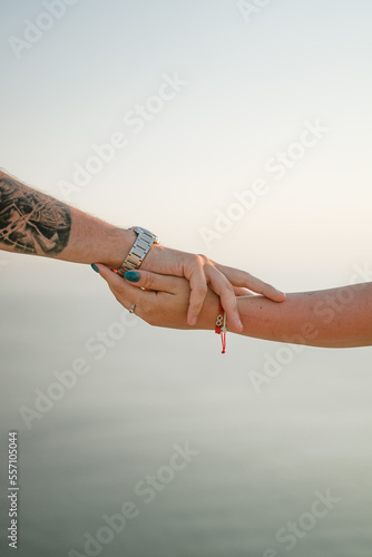 a man and a woman hold hands against the backdrop of an endless sea, a supportive photo