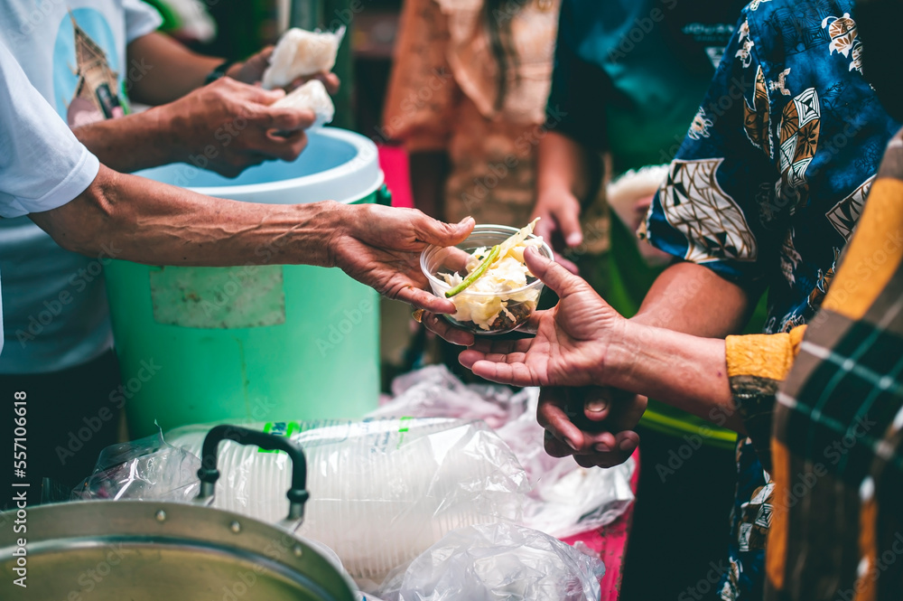 Obraz premium Hands of hungry beggar requesting free food from volunteers : concept of giving and sharing