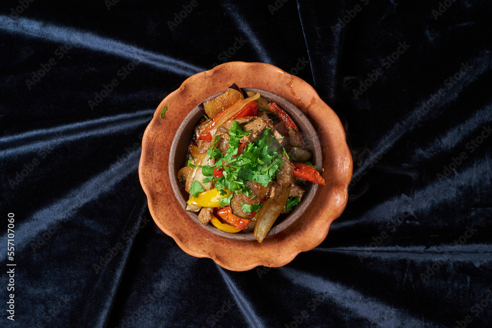 meat with vegetables and herbs on a black background