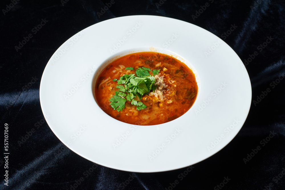 soup in a white plate, on black velvet soup in a white plate, on black velvet
