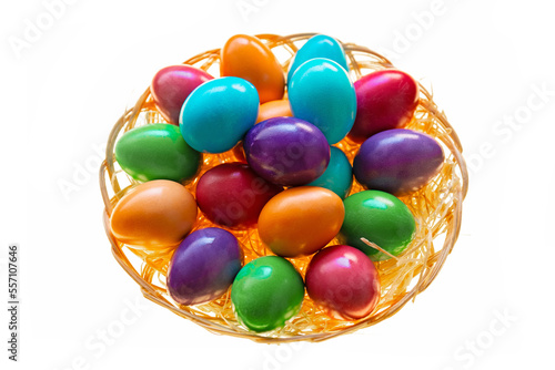 Easter multicolored painted eggs close-up in a wicker bowl on a white background.Easter food. Spring religious holiday symbol. Easter tradition. Christian and Catholic tradition holiday.