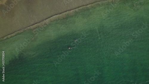 Amazing aerial view of a couple snorkelling at Black rock beach Tobago on a sunny day photo