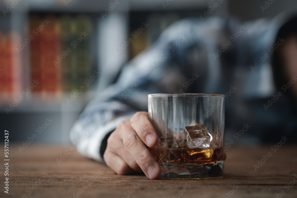 Man holding a glass of brandy, he is drinking brandy in a bar, drinking alcohol impairs driving ability and can damage health. The concept of drinking alcohol. Man holding a glass of brandy, he is drinking brandy in a bar, drinking alcohol impairs driving ability and can damage health. The concept of drinking alcohol.