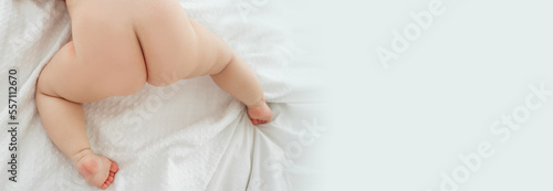 Obraz na płótnie Baby butts. Baby is lying on bed waiting for pediatric massage oil. Top view. Copy space for advertisement. w salonie