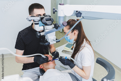 A modern dental clinic with a microscope for treating patients. A dentist uses a microscope to examine a patient s teeth. Medical equipment  dental clinic.