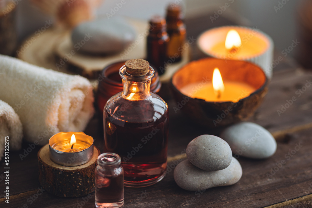Concept of natural essential organic oils, Bali spa, beauty treatment, relax time. Atmosphere of relaxation, pleasure. Candles, towels, dark wooden background. Alternative oriental medicine Concept of natural essential organic oils, Bali spa, beauty treatment, relax time. Atmosphere of relaxation, pleasure. Candles, towels, dark wooden background. Alternative oriental medicine