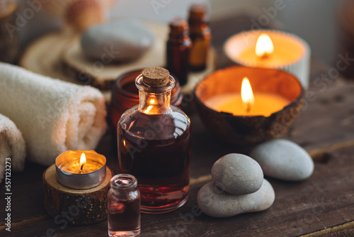 Concept of natural essential organic oils, Bali spa, beauty treatment, relax time. Atmosphere of relaxation, pleasure. Candles, towels, dark wooden background. Alternative oriental medicine