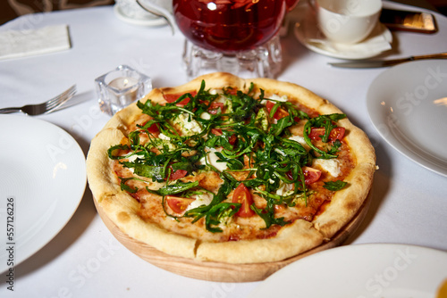 pizza with tomatoes and dandelion leaves