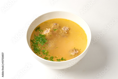 soup with meatballs in a white plate on a white background