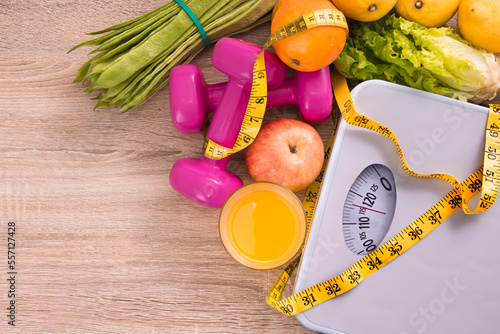 vegetarian food, dumbbells, tape measure and scale, concept of diet and health photo