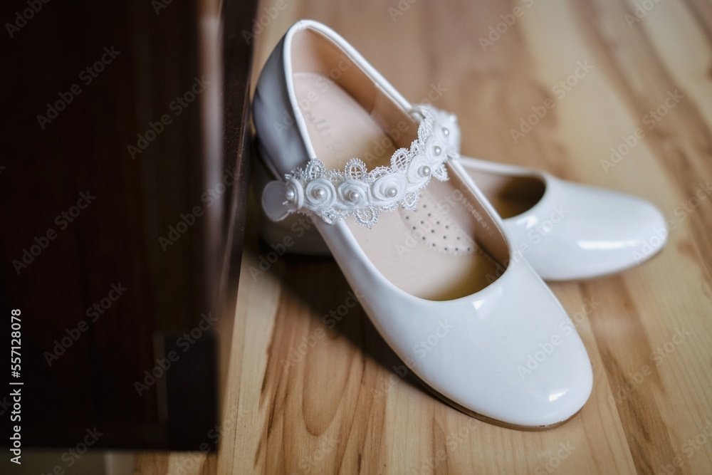 Obraz na płótnie białe buty komunijne dziewczęce w salonie