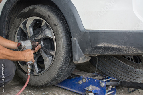 Car mechanic changing wheels in car,Tire repairer © Suwatchai