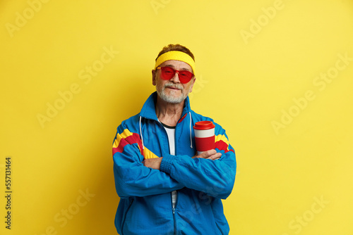 Smiling Man Posing Studio. Portrait of Happy Senior Man Standing and Smiling. Indoor Studio Shot, Isolated on Yellow Background 