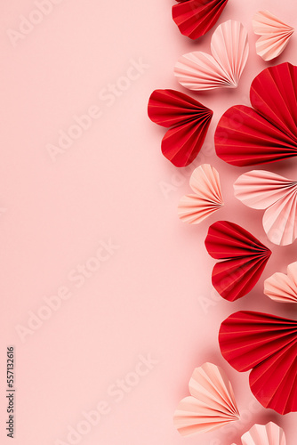 Obraz na płótnie Valentine day background with sweet love pink and red paper hearts of asian fans in modern fashion style soar on cute soft light pastel pink backdrop, sideways border, copy space, top view, vertical
