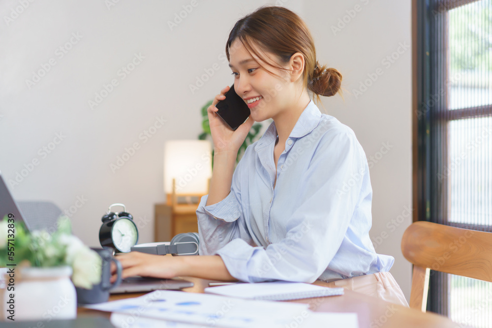 Remote business concept, Businesswoman talking with client on smartphone and typing data on laptop Remote business concept, Businesswoman talking with client on smartphone and typing data on laptop