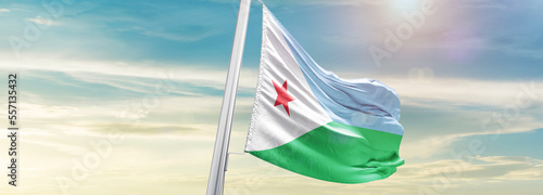 Waving Flag of Djibouti in Blue Sky. The symbol of the state on wavy cotton fabric. photo