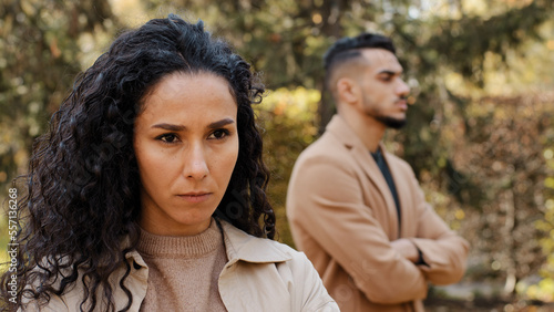 Close up offended upset disappointed girl woman wife girlfriend ignore angry guy man standing on blurred background outdoors. Ethnic multiracial couple family quarrel woman conflict misunderstanding