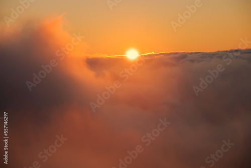 Beautiful sunset   sunrise cloudy sky from aerial view with gentle colorful clouds and dramatic light. Airplane view above clouds. Vivid twilight sky painted by the sun leaving bright golden shades