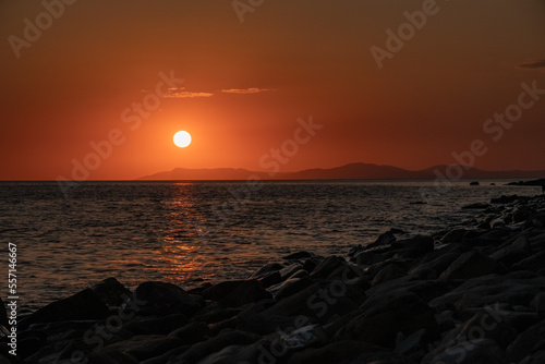  Sunrise in the morning over the sea shining crimson lights on sky and sea water surface with a bird flying in the sky. High quality photo