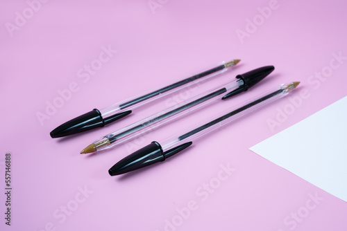 selected focus on ballpoint pen tip and black pen tops isolated on pink background with white paper