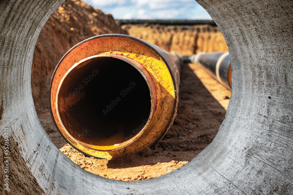 Insulated pipe. Large metal pipes with a plastic sheath at a construction site. Modern pipeline for supplying hot water and heating to a residential area. Close-up.
