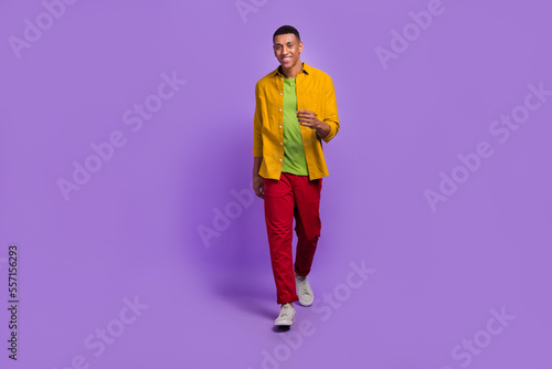 Full body photo of cheerful nice person have good mood walking isolated on violet color background