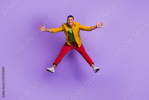 Full length photo of overjoyed cheerful person jumping falling have good mood isolated on violet color background
