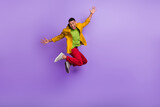 Full body photo of active overjoyed person jumping raise hands isolated on violet color background