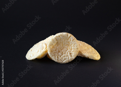 Puffed Potato Chips, Stacked on a plain black background with shadow, healthy potato snack.Puffed chis  photo