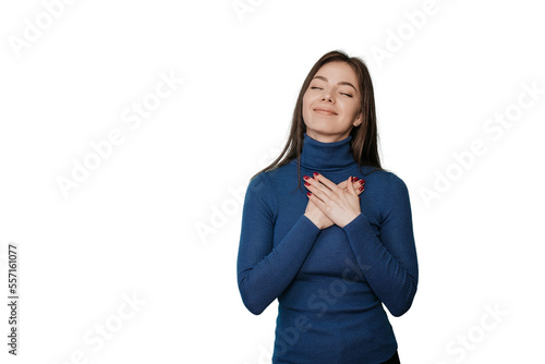 Eyes closed thankful Italian woman presses palms to heart expresses positive feelings, over transparent background feels touched to get help, makes gratitude gesture, in blue sweater, smiles sincerely
